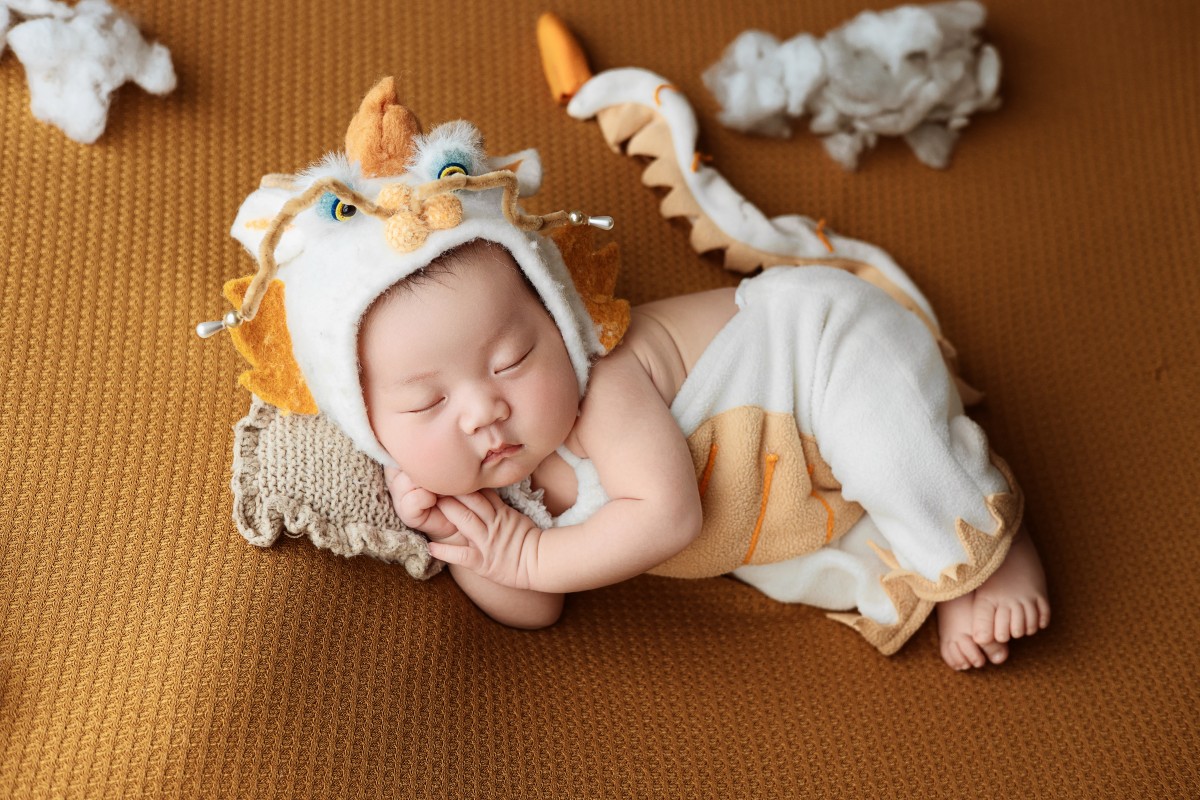 6K壁纸|头戴龙帽，身披龙尾，百天的小萌娃在暖光里酣眠-觅屏壁纸