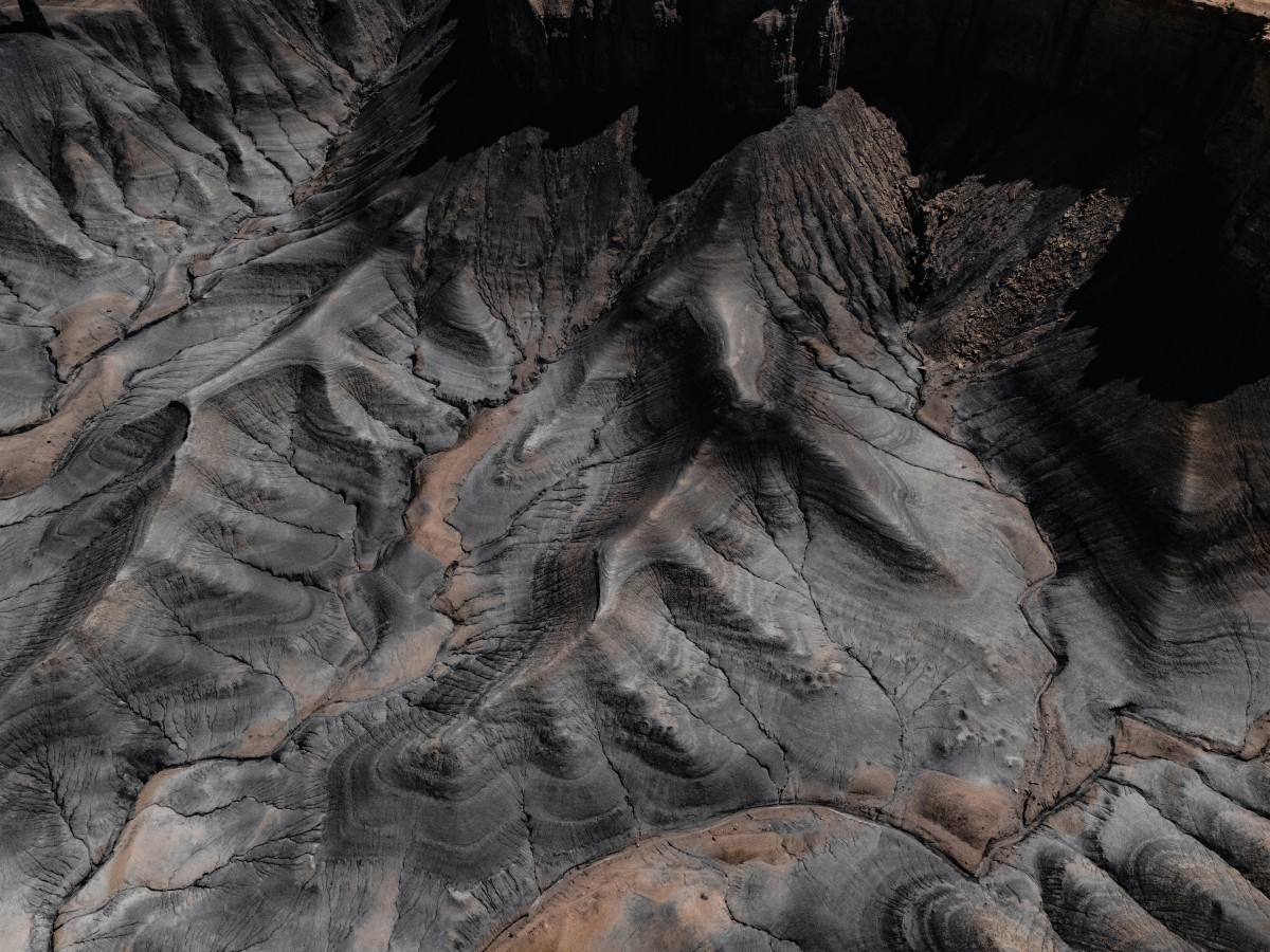 8K壁纸|亿万年的刻痕：当水流与风在荒原上雕刻，大地的肌理如凝固的浪涛-觅屏壁纸